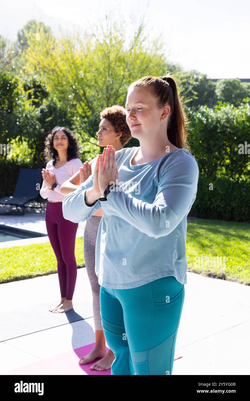 Yoga im Freien üben, verschiedene Freundinnen meditieren gemeinsam auf Yogamatten Stockfoto