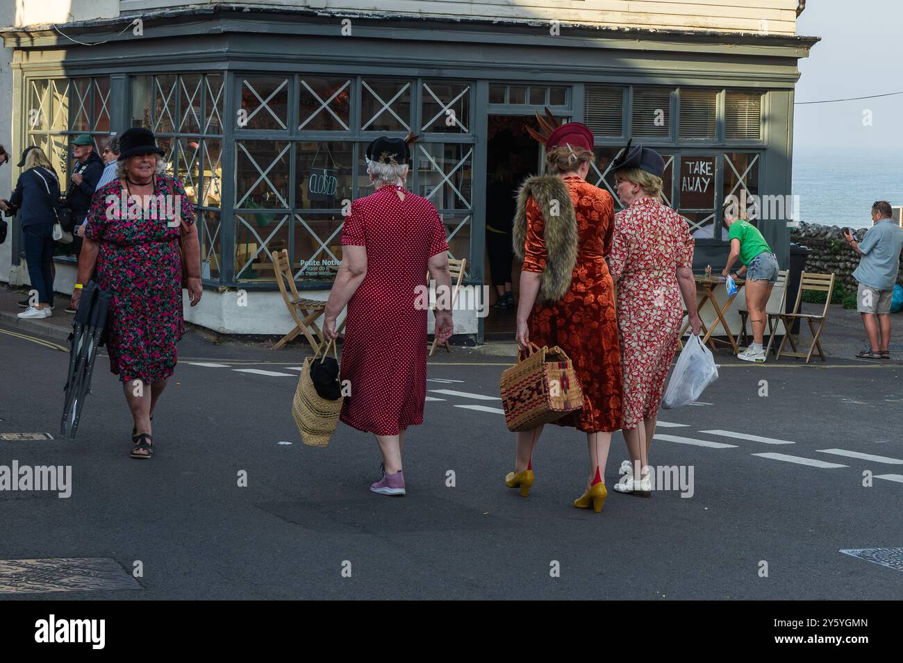 Sheringham, Norfolk, Großbritannien - 21. SEPTEMBER 2024: Foto von Frauen in eleganten Vintage-Kleidern der 1940er Jahre, die während des Wochenendes der 1940er auf der Straße sprechen Stockfoto