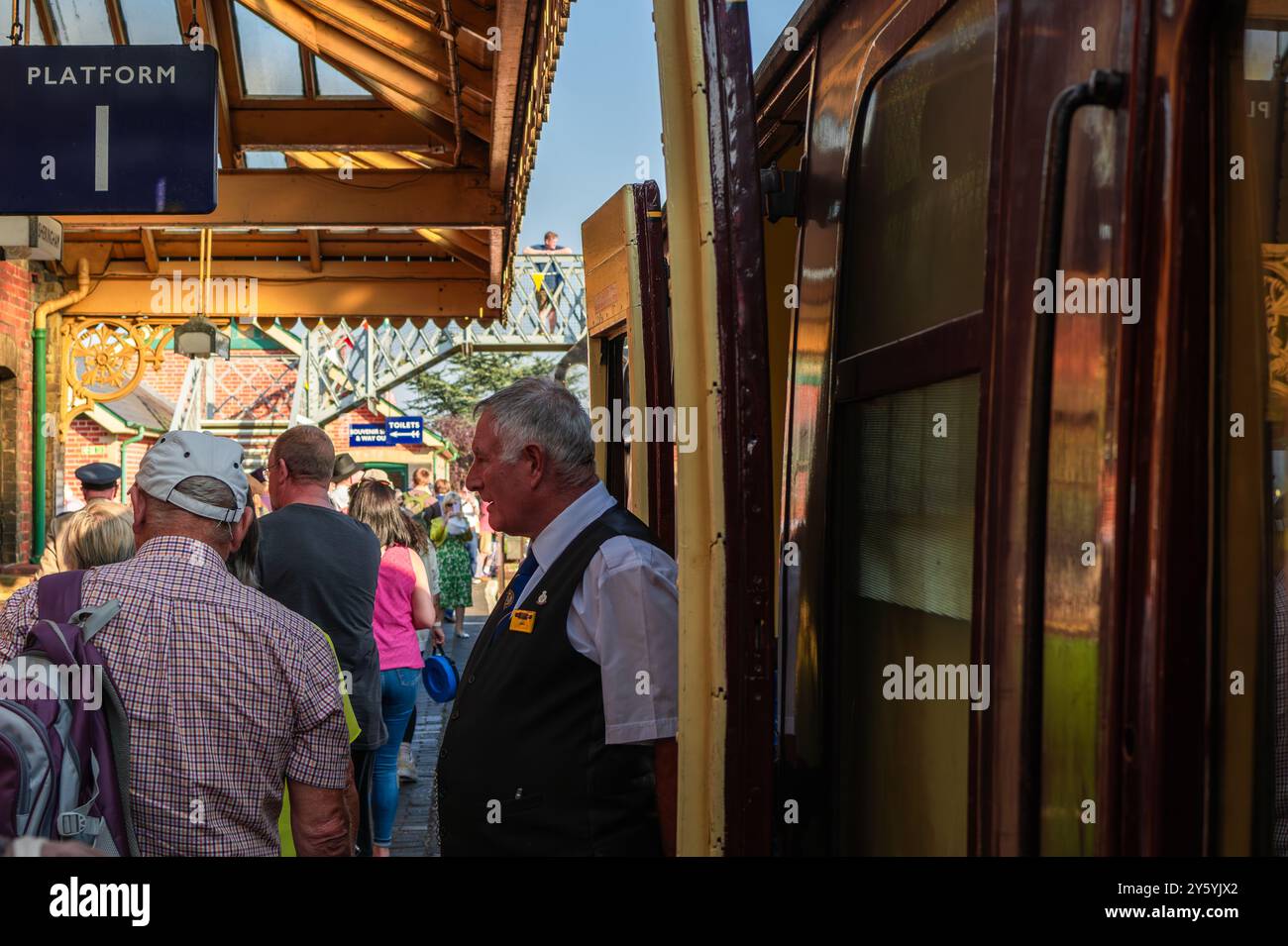 Sheringham, Norfolk, Vereinigtes Königreich - 21. SEPTEMBER 2024: Alter Mann mit weißen Haaren in klassischer Zugbegleiterkleidung aus den 1940er Jahren verlässt die Dampflokomotive durin Stockfoto