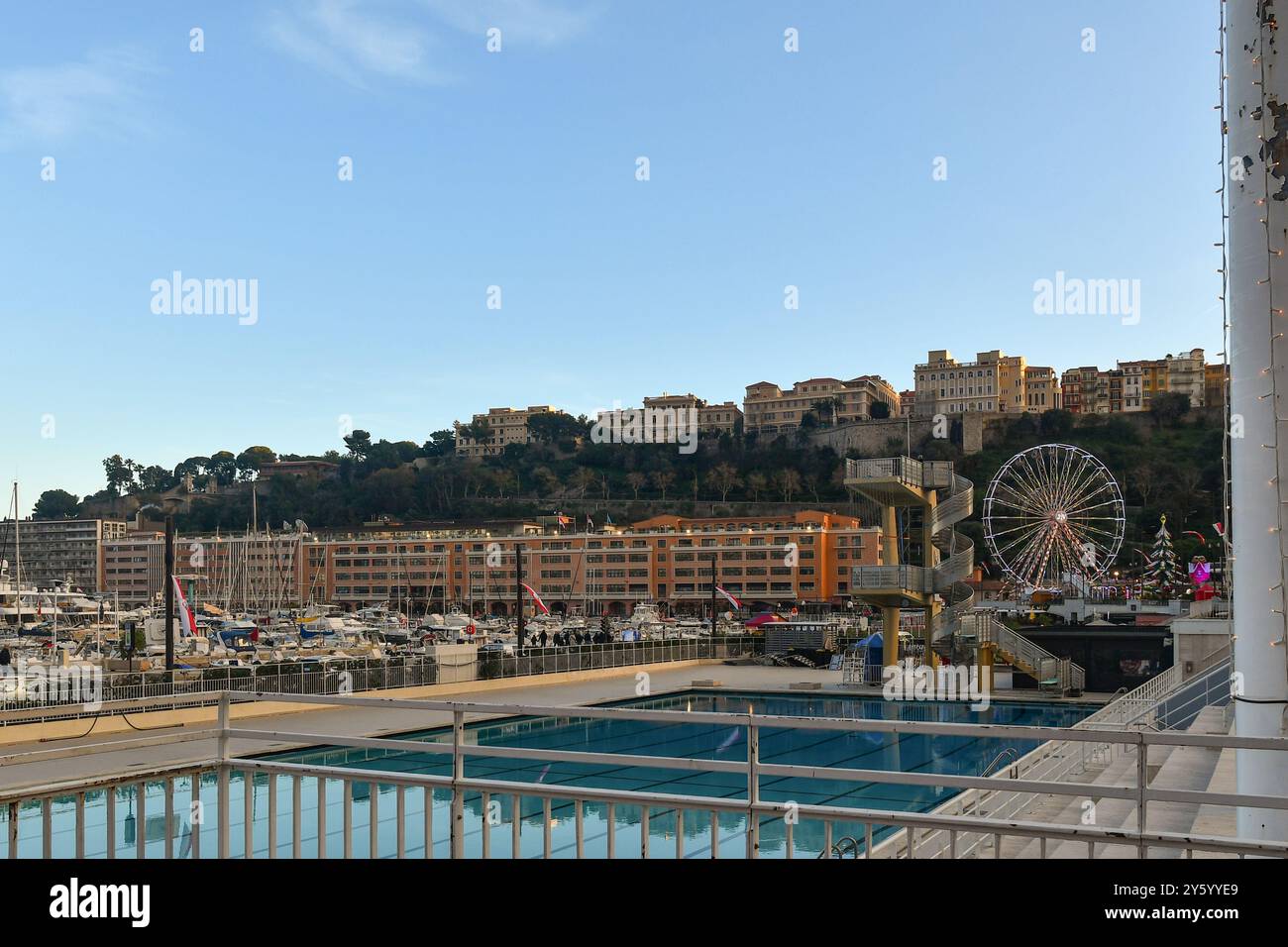 Der Swimmingpool des Rainier III Nautical Stadions mit Blick auf Port Hercule, mit dem Felsen von Monaco im Hintergrund bei Sonnenuntergang, Monte Carlo Stockfoto