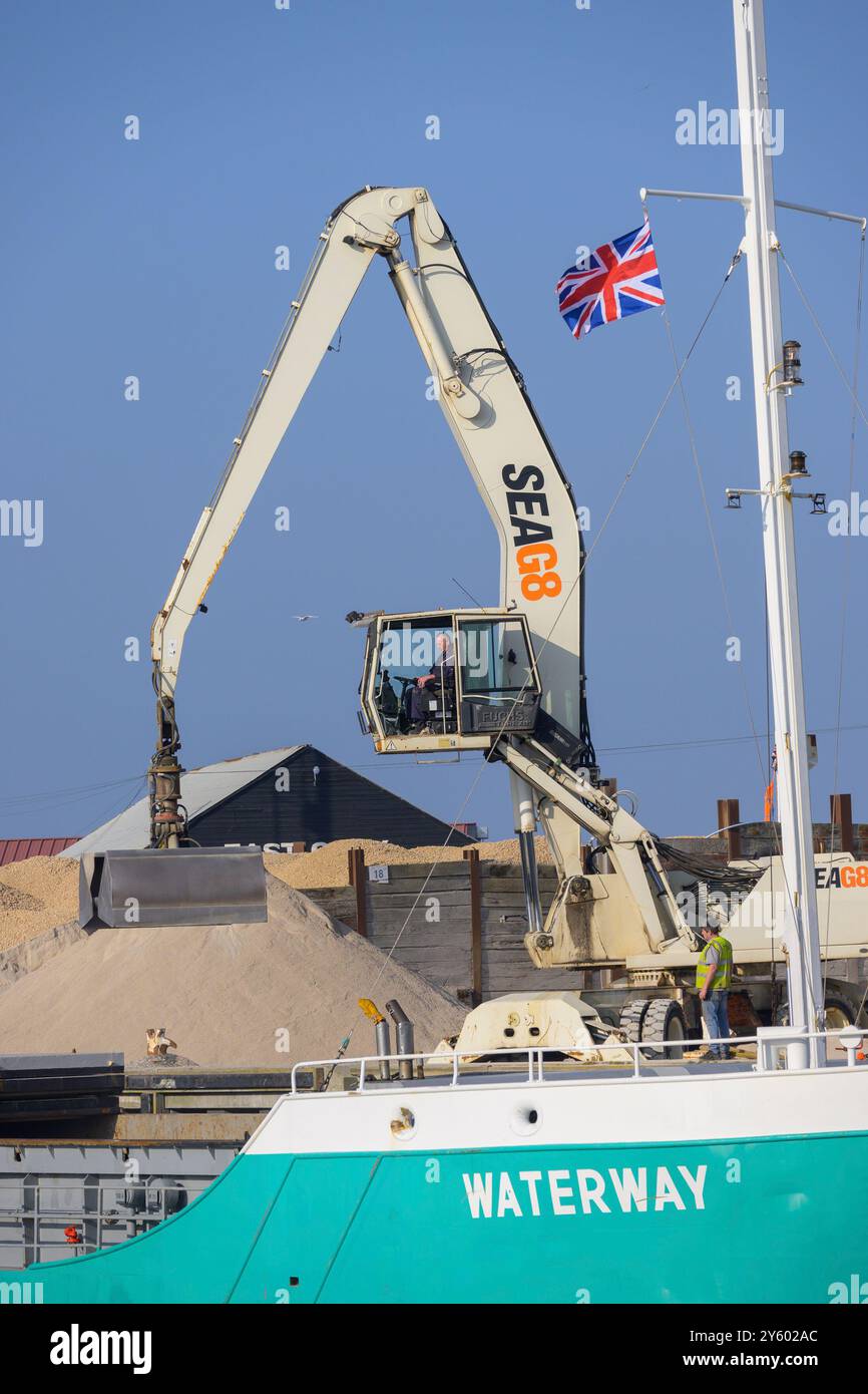 Whitstable, Kent, England, Großbritannien. Terex Fuchs (im Besitz von SEAG8), der Kies auf das Frachtschiff Waterway auf dem EastQuay verlädt Stockfoto
