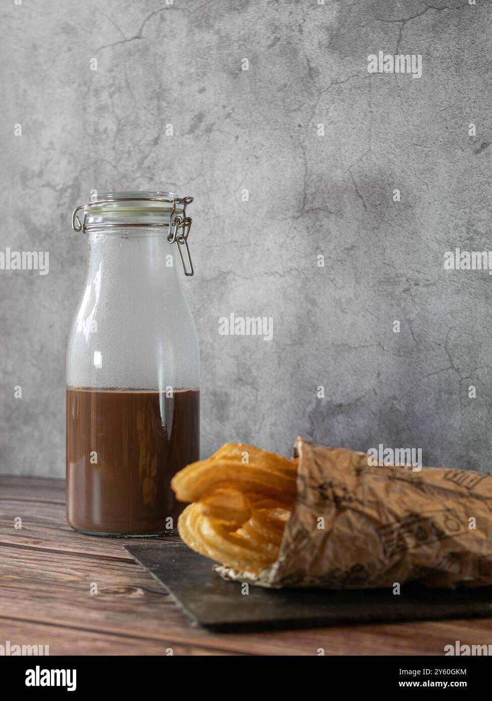 Vertikale Fotografie von Schokolade mit Churros. Traditionelles und köstliches Frühstück und Snack Stockfoto