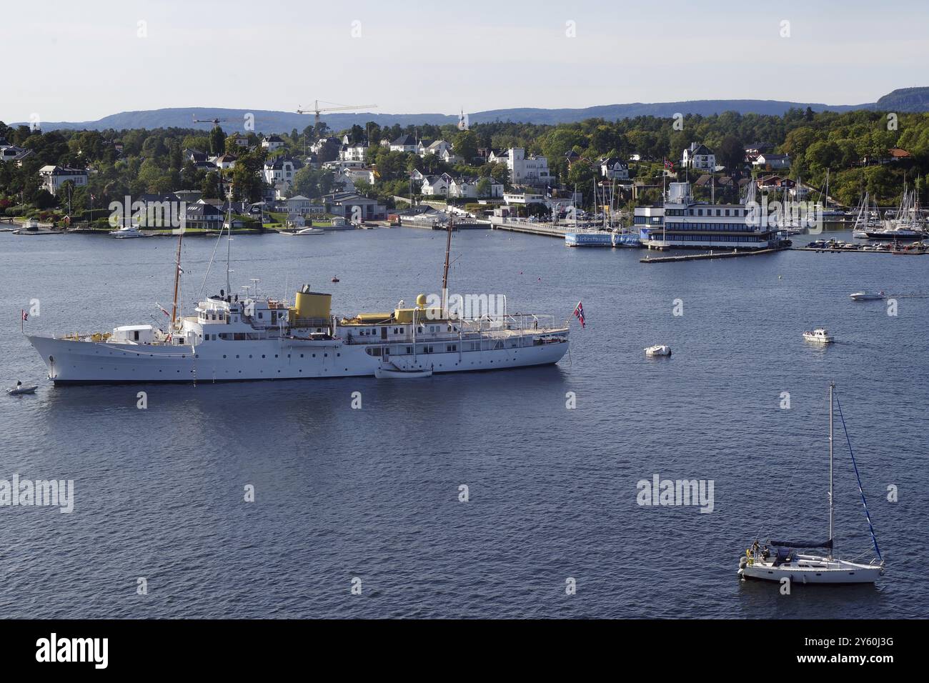 Küste mit Schiffen und Booten, umgeben von Häusern und Hügeln voller Bäume, die Jacht der königlichen Familie, Museum Halbinsel, Hauptstadt, Oslo, Norwegen, Euro Stockfoto