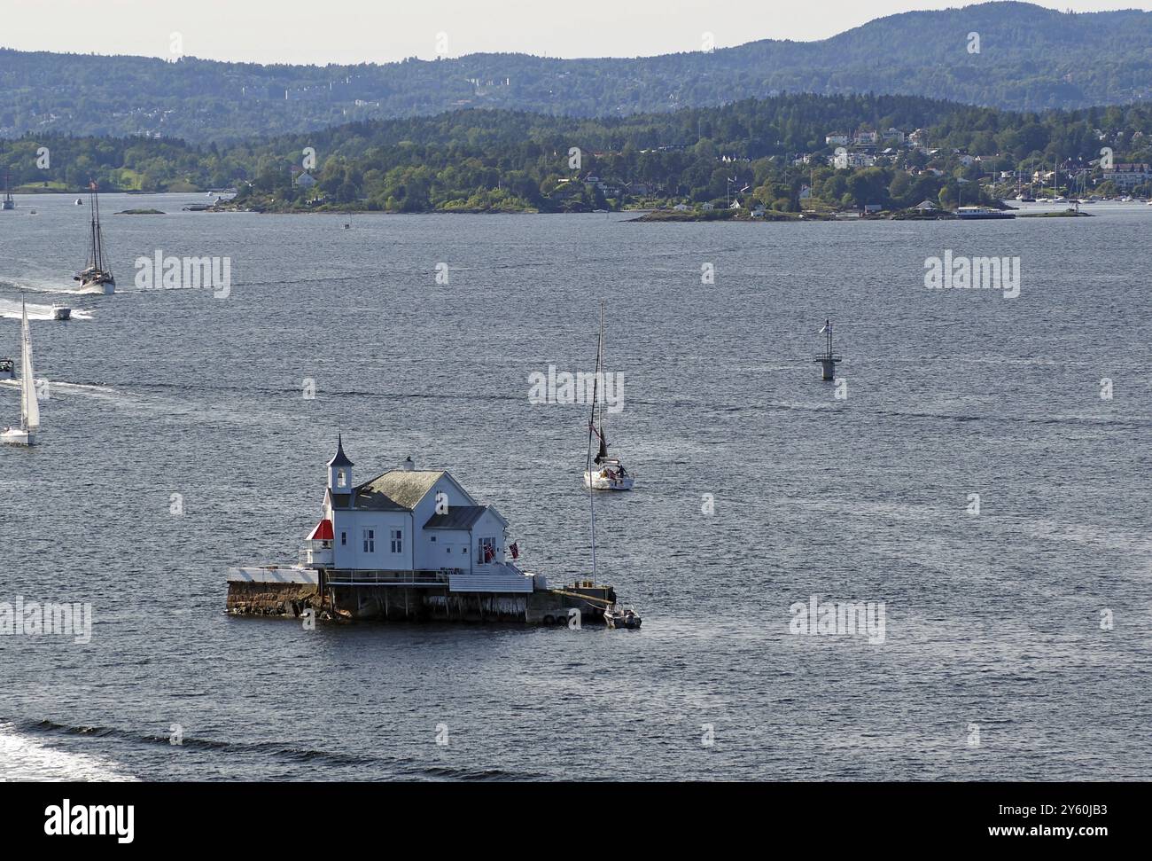 Kleiner Leuchtturm auf einer Insel im Wasser, umgeben von Booten und Hügeln in der Ferne, Dyna Fyr, Oslofjord, Hauptstadt Oslo, Norwegen, Europa Stockfoto