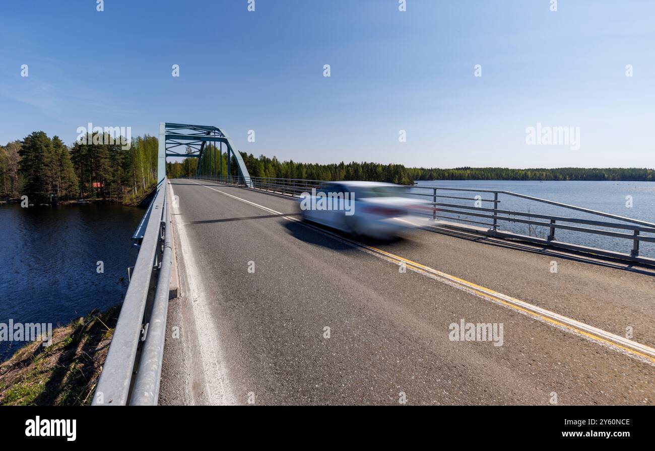 Weißes Auto überquert die finnische Straßenbrücke Kivisalmi in Summer, Finnland Stockfoto