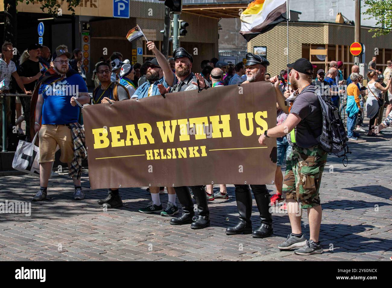 Bärtige Männer mit Bär mit uns Banner bei der Helsinki Pride 2024 Parade in Helsinki, Finnland Stockfoto