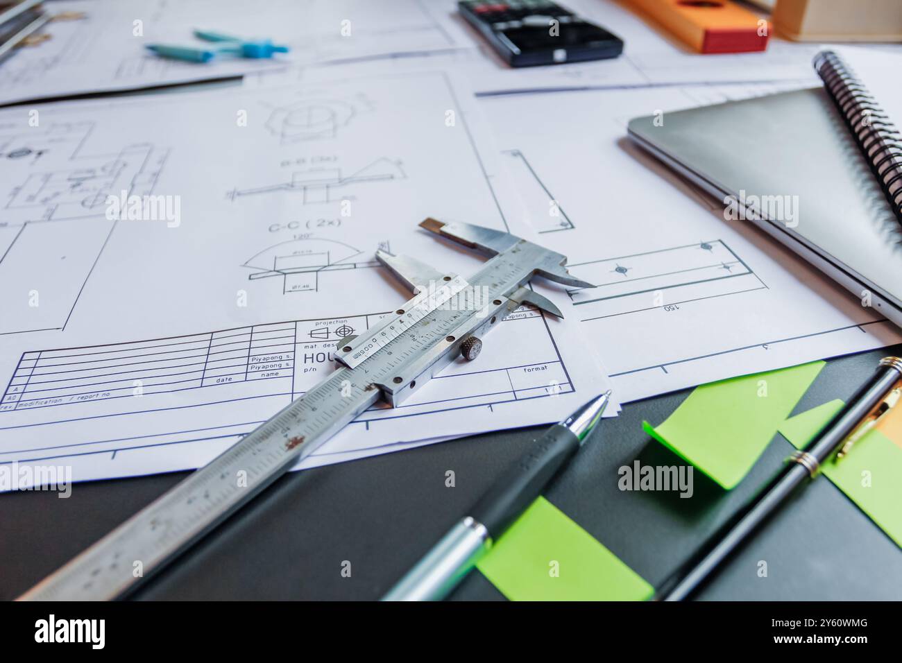 Arbeitsgeräte, die im Büro eines Teams aus Ingenieuren und Architekten auf dem Schreibtisch platziert werden, entwerfen ein großes Bauprojekt, um die Bedürfnisse der Investoren zu erfüllen und fea zu überprüfen Stockfoto