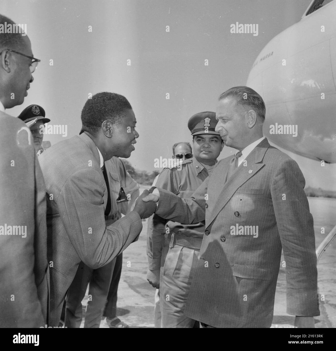 Der Generalsekretär der Vereinten Nationen Dag Hammarskjold, der gestern mit 240 schwedischen Soldaten der Vereinten Nationen in Elisabethville, Katanga, ankam, schüttelt Herrn Tshombe, dem selbsternannten Präsidenten des abtrünnigen Landes Katanga, die Hand. Auf dem Flughafen war seine Ankunft durch Anfeuerungen und eine Verhaftung gekennzeichnet. Der Beifall war für Tshombe, hauptsächlich von Hunderten versammelter Belgier gegen die Vereinten Nationen gerichtet. UN-GENERALSEKRETÄR DAG HAMMARSKJOLD MIT ELIZABETHVILLE TSHOMBE / 13. AUGUST 1960 Stockfoto