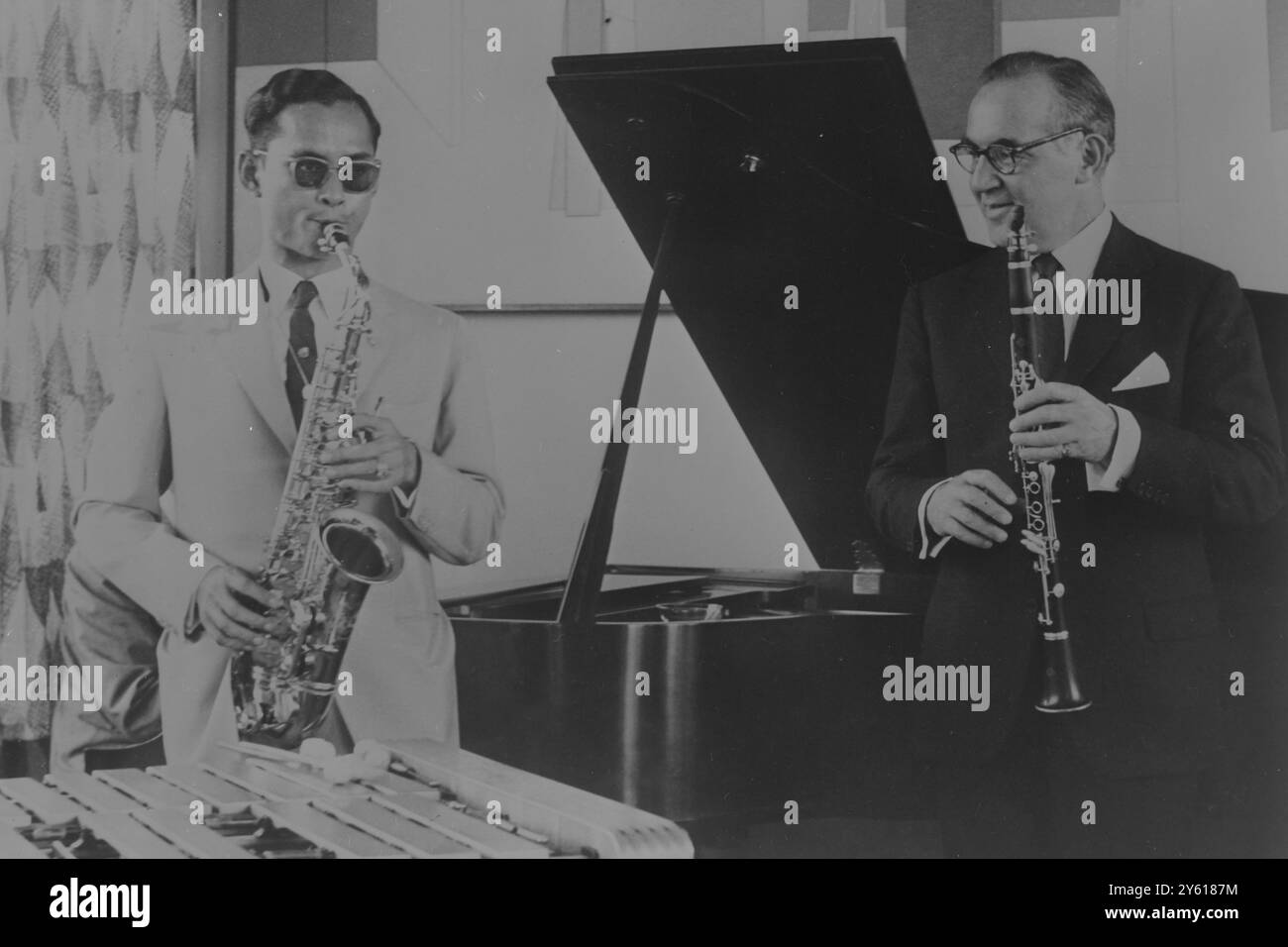 New York : der berühmte US-Bandleader Benny Goodman (rechts) und King Bhumibol aus Thailand unterhalten sich bei einer spontanen Jam-Session in der Wohnung des ersteren. Bei seiner Ankunft am 5 . Juli 1960 wurde der thailändische König mit einem aufregenden Dreiband-Klebeband begrüßt . The King , der Musik schreibt und Altsaxophon spielt , wurde in Cambridge , Mass geboren und ist derzeit mit seiner Frau Queen Sirikit auf Tournee durch die Vereinigten Staaten . 7. Juli 1960 Stockfoto