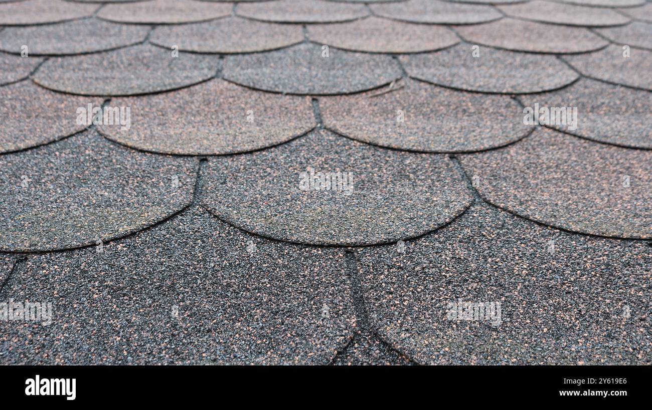 Fragment einer weichen Dachverkleidung mit granularer Textur und abgerundeten Kantenlinien in grau-rotem Farbton, industriell strukturierte Hintergrundoberfläche Stockfoto