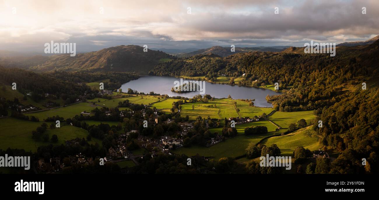 Luftpanorama-Landschaft des Dorfes und des Sees von Grasmere im Lake District National Park mit einem wunderschönen Sonnenaufgang und ruhigem Wasser Stockfoto