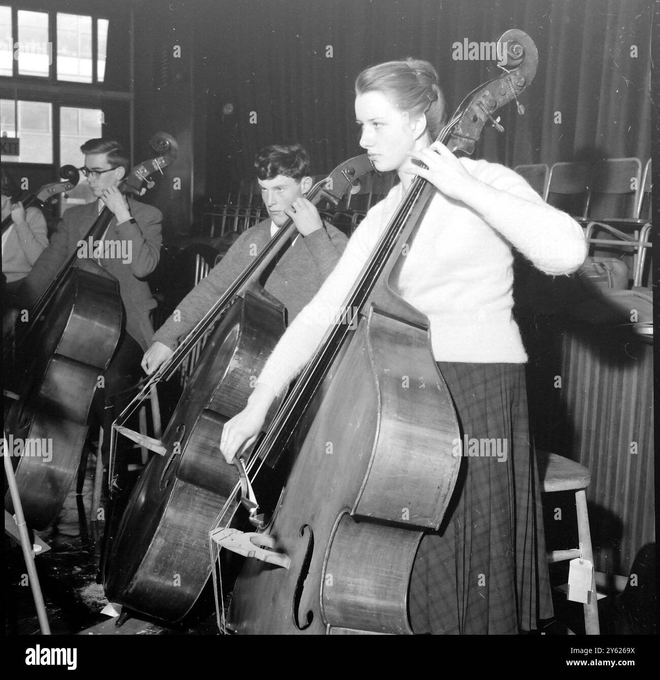 LONDON EIN WEIHNACHTSKURS DES LONDON SCHOOLS SYMPHONY ORCHESTRA IN VORBEREITUNG AUF IHR KONZERT AM 18. JANUAR IN DER LONDONS ROYAL FESTIVAL HALL BEGANN AN DER QUINTIN SCHOOL IN ST JOHNS WOOD, LONDON. FOTOSHOWS : JAN COLEMAN AUS PECKHAM IN LONDON UND DER 17-JÄHRIGE DAVID CLARK AUS GUILDFORD, DER ERNSTHAFT ÜBER IHRE BOGENARBEIT AN DEN GROSSEN KONTRABÄSSEN WÄHREND DER PROBEN NACHDENKT. 28. DEZEMBER 1959 Stockfoto