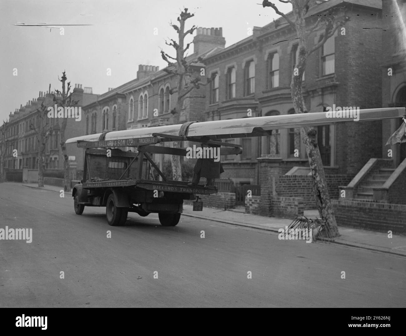 Dunkelblaues Boot. Die Oxford University Shell wurde im Rutland Boat House von Mr. George Sims in Hammersmith gebaut und ist praktisch bereit für ihr einheimisches Element. Das schlanke neue Schiff ist 62 m lang, 2,5 m breit und 10 cm tief. Er kann eine Besatzung mit einem durchschnittlichen Gewicht von 12 Steinkronen und 9 Pfund tragen. Das Bild zeigt: 'Rolling to the River' das Oxford-Boot wird heute Morgen in Hammersmith auf einen LKW für Henley geladen. (Freitag). 20. Februar 1948. Stockfoto