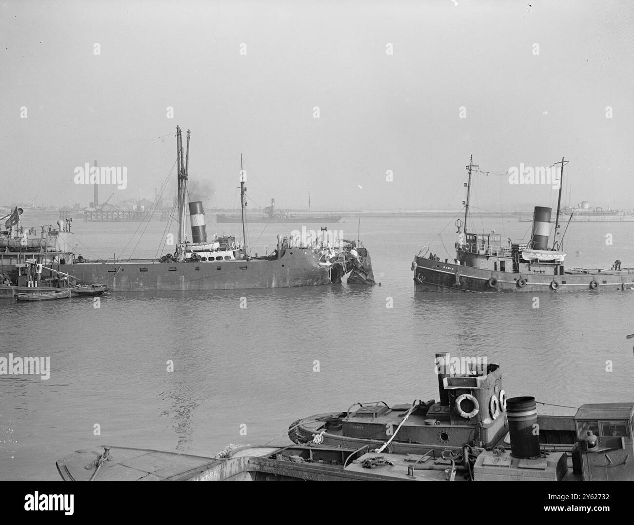 Zwei Männer werden vermisst, als ertrunken geglaubt und ein dritter mit allen ins Krankenhaus eingeliefert, nach der Kollision des 2.373 Tonnen schweren Collier „Corcrest“ mit dem 5.853 Tonnen schweren Elder-Dempster „Freetown“ vor Erith, Kent. Das Bild zeigt: Schlepper stehen am beschädigten Corcrest, am Callender Jetty, Erith REACH, nach der Kollision heute. Ein Taucher ist dabei, die Schäden unter der Wasserlinie zu untersuchen. 1. Februar 1948 Stockfoto