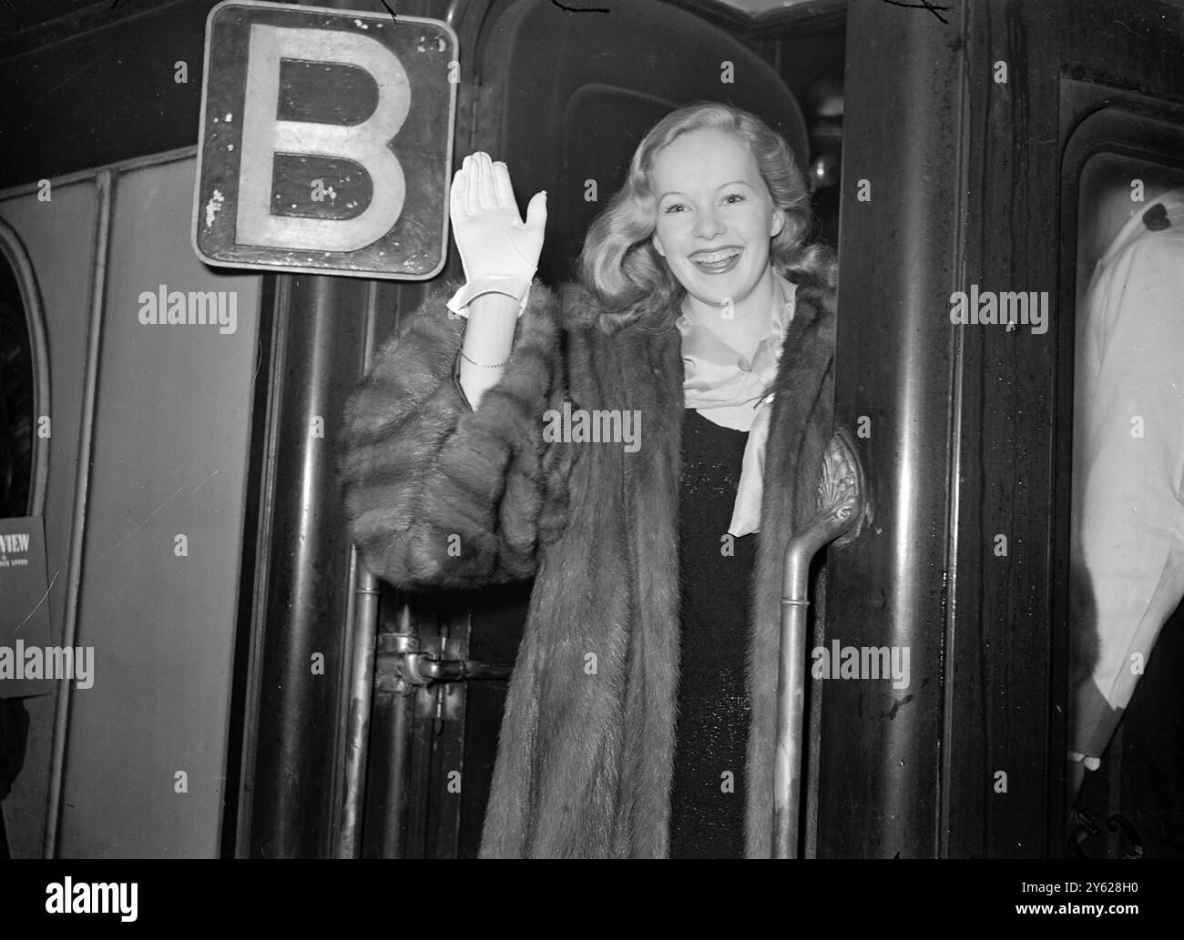 Mit einer Abschiedswelle zum verregneten London verlässt Filmstar Peggy Cummings Waterloo und den „Queen Elizabeth“-Bootszug, heute von Southampton und New York. 16. Januar 1948 Stockfoto