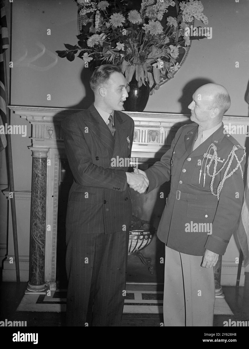 Die Auszeichnungen und Auszeichnungen der Vereinigten Staaten für die Verdienste um die alliierte Sache während des Krieges wurden heute von Col Ernest Bomar, stellvertretender Militärattaché der Vereinigten staaten, in der Residenz des US-Botschafters in London an 25 britische Offiziere und Zivilisten sowie einen griechischen Bürger verliehen. Das Bild zeigt: Sergeant J.D. Vallely, von Carlisle mit dem Col Bomar während der Zeremonie, wo er die Medaille der Freiheit der Präsentation erhielt. 15. Januar 1948 Stockfoto