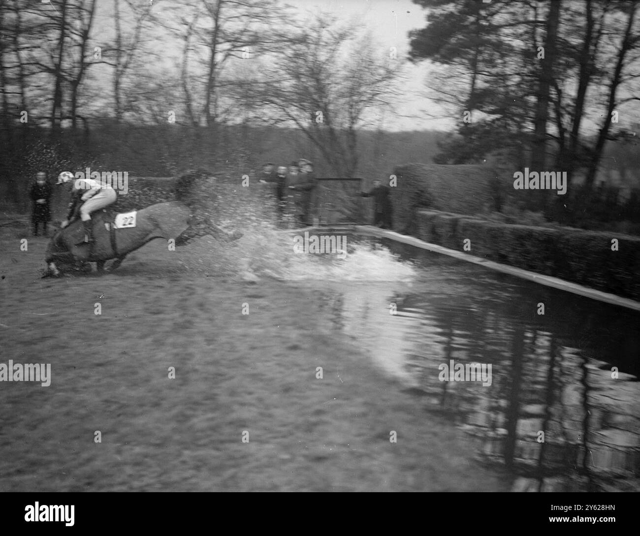 Mr. C. Bones' 'Was ist das?', (Brogan oben), findet die Frage beantwortet, als er über die Wasserschanze in der heutigen Felcourt Handicap Turmjagd im Lingfield Park trauert. 16. Januar 1948 Stockfoto