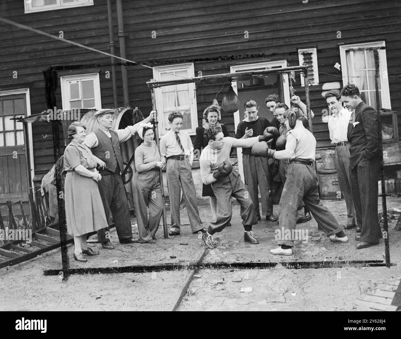Harry McMurdie, 22-jähriger Ex-Marinemonder, von Edgware, Middlesex, ist ein Boxer, der nie nach Sparringspartnern suchen muss. Fünf von sieben Brüdern sind oder waren Amateurexponenten der Kunst, und sein Vater, der noch einige harte Runden im Spiel ist, war ein hervorragender Armeeboxer. Diese Mitglieder seiner Familie, zusammen mit Mutter, Schwester, Schwägerin und Verlobter, füllen mindestens ein Dutzend Plätze am Ring, wenn Harry kämpft. So ermutigt, hatte dieser vielversprechende junge Kämpfer während seiner kurzen beruflichen Laufbahn 17 Kämpfe ohne Niederlagen. 13 wurden in t gewonnen Stockfoto