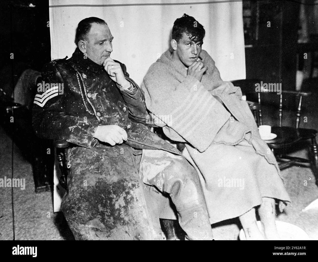 Vier Männer und ein Junge, ganz Hull verbrachten fünf Stunden in einem sinkenden Schiff, das ständig in Gefahr war, umzustürzen, und retteten für eine improvisierte Brücke, die in den nebelumhüllten Humber River gebaut wurde. Die fünf waren die Besatzungen von zwei Lastkähnen. Einer der "Grraveller" schleppte zwei weitere Lastkähne. Der zweite Lastkahn stürzte nach vorne und bohrte den Graveller mit ihrem Anker. Graveller sprang auf den zweiten Lastkahn, der herumlief und wahrscheinlich eine Schildkröte drehen würde. Das Bild zeigt: Polizeibeamter A.J. Trott organisierte den Bau der Rettungsbrücke und Dennis Sherburn, 19 Jahre alt, einer der geretteten Crew, mit seiner Stockfoto