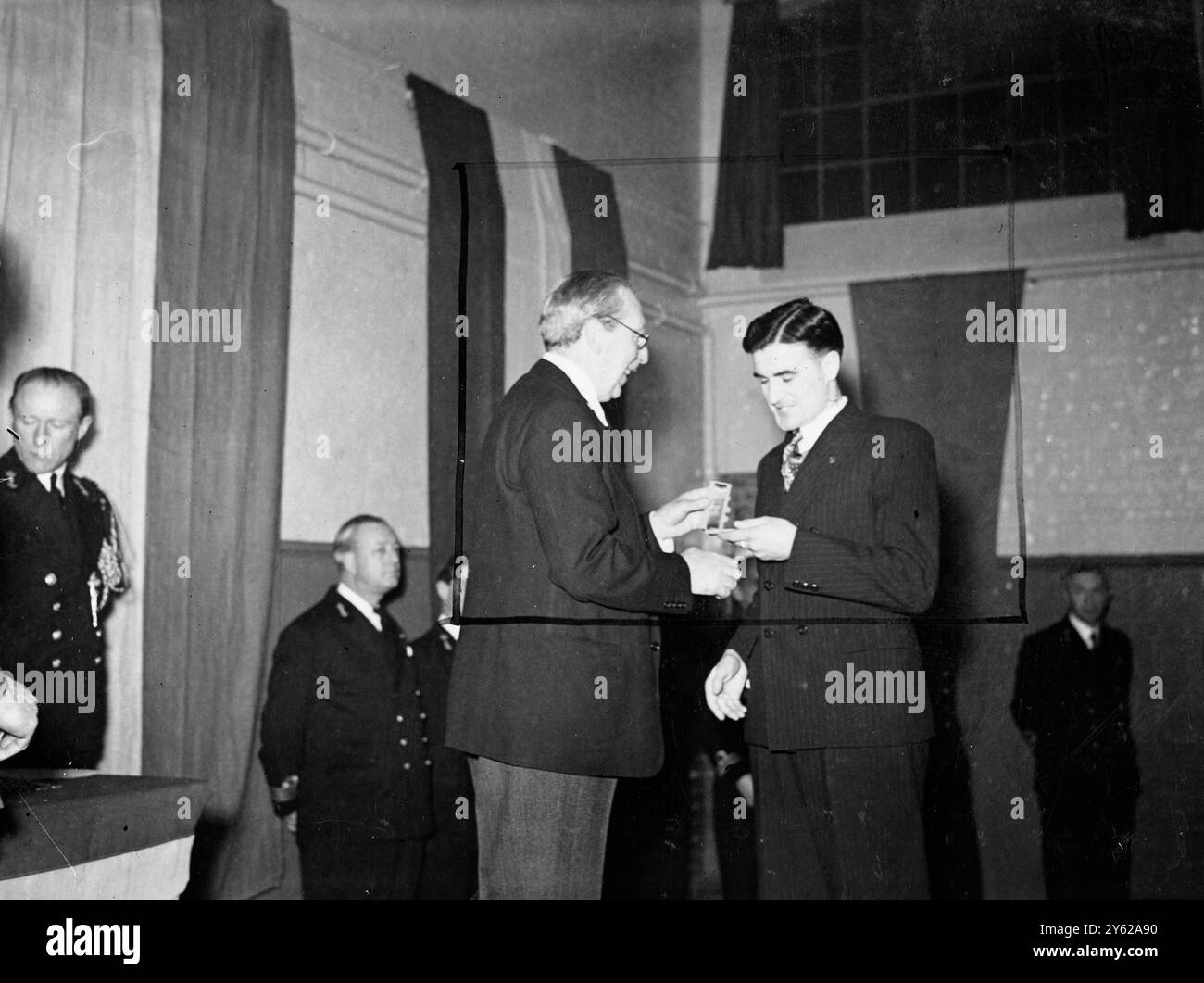 Einige britische Offiziere und Männer nahmen heute Nachmittag an einer Einweihung in der Drill Hall, Duke of York's Barracks in Chelsea Teil, wo sie von Jonkheer Michiels Van Verduynen, dem niederländischen Botschafter, die Auszeichnung für ihre Dienste und die Befreiung Hollands erhielten. Foto zeigt: Sgt. E.P. Kelly von St. Helen's Lancs., erhält heute die Silbermedaille des Ordens von Orange Nassau vom niederländischen Botschafter bei der heutigen Einsetzung. 11. Dezember 1947 Stockfoto