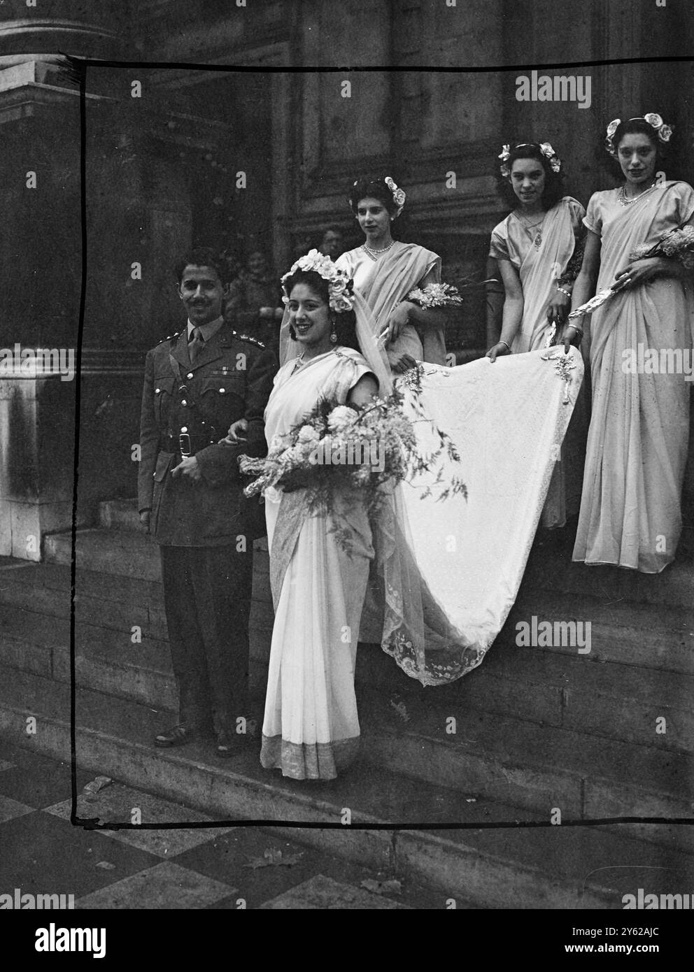 Die Hochzeit von Monica, der einzigen Tochter des verstorbenen Mr. J. K. das Gupta und B.E.Rodriguez, der Royal Indian Artillery, des einzigen Sohnes von Mr. Und Mrs. Rodriguez aus Bombay - jetzt in diesem Land pensioniert - fand heute Morgen im Brompton Oratory London statt. Die Braut ist die Enkelin des bekannten Autors und Tuberkulosespezialisten David C. Muthu und reist nach der Hochzeit mit ihrem Mann nach Indien. 3 Meter Silber wurden im Zug des Brautkleides verwendet, das im östlichen Stil war. Das Bild zeigt: Mit ihren drei Brautbegleitern in harmonisierenden Kostümen und ihrem drei-Meter-Silberzug hell Stockfoto