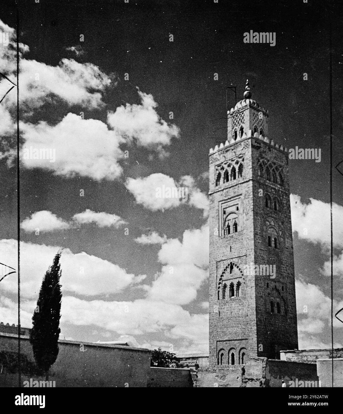 Die Koutoubia-Moschee in Marrakesch ist ein Juwel maurischer Kunst mit einem 220 Meter hohen Minarett, dessen Seiten mit einem hochgradig verarbeiteten Mosaik aus türkisblauem Blau bedeckt sind und das von drei vergoldeten Kugeln übereinander gesetzt wird. Der niedrigste ist 1,5m Durchmesser, die nächsten 1,5m und die obersten 1,5m. Die Legende besagt, dass die drei Kugeln ursprünglich aus Gold waren, geschmolzen aus den Juwelen der Braut eines Sultans. 19. Dezember 1947 Stockfoto