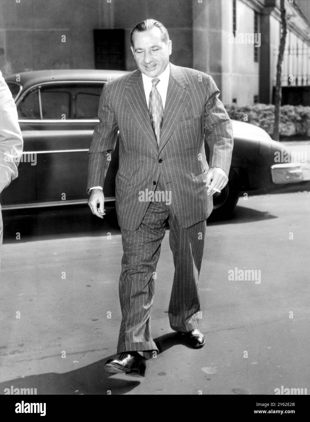 Der Gambler Frank Costello, der als Unterweltzar bekannt ist, kam im Federal Court House am New York Foley Square an, um sich dem US-Marshal zu ergeben. Dies war der erste Schritt auf Costellos Reise in eine Zelle in einem Bundesgefängnis, um eine 128-monatige Strafe wegen Verachtung des Senats abzusitzen. Die Verurteilung entstand aus den Ermittlungen des Kefauver Crime Committee. Es ist das erste Mal, dass Costello seit 1915 16. August 1952 inhaftiert ist. Stockfoto