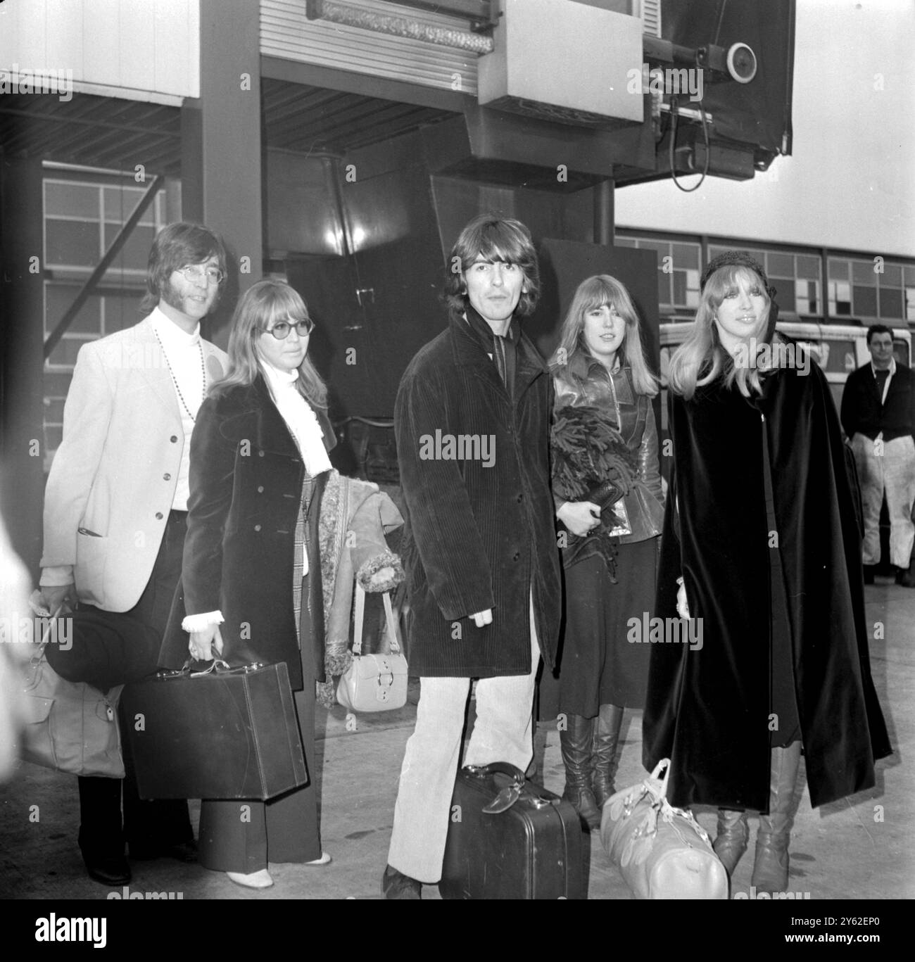 London: Beatle John Lennon und George Harrison heute am Flughafen London (Heathrow) mit ihren Ehefrauen Cynthia (neben John) und Pattie (rechts). Zwischen George und Pattie ist ihre Schwester Judy Boyd, die die anderen vier nach Indien begleitet, um mit Maharishi Mahesh Yogi zu meditieren. 15. Februar 1968 Stockfoto