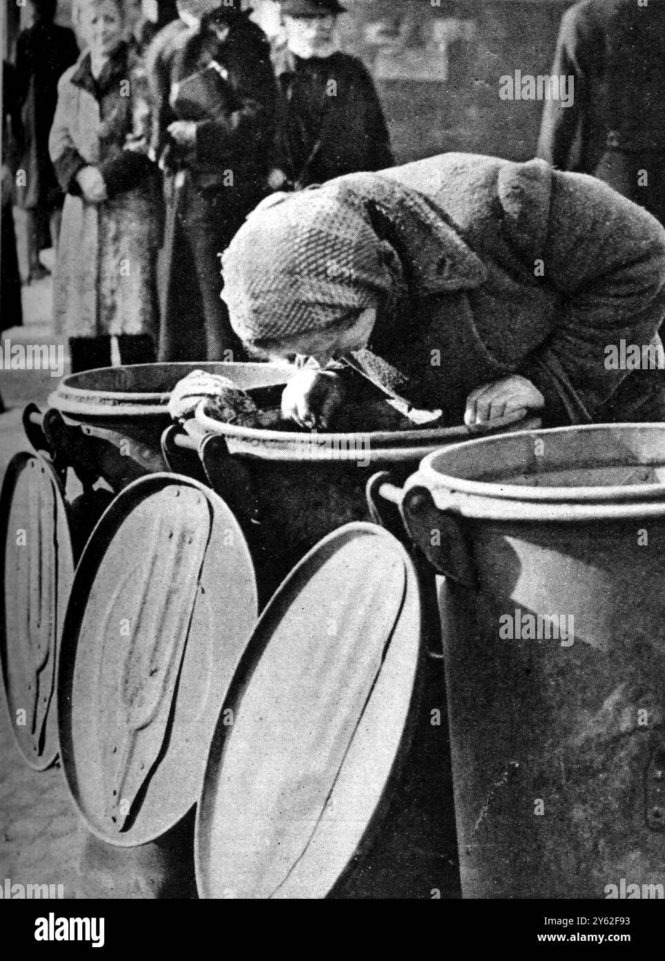 Das hungrige Hamburg, wo Rationseinschnitte begannen. Die Suche nach Essen, eine Hamburger Frau, die durch Mülltonnen sucht, in der Hoffnung, etwas zu essen zu finden. 1946 Stockfoto