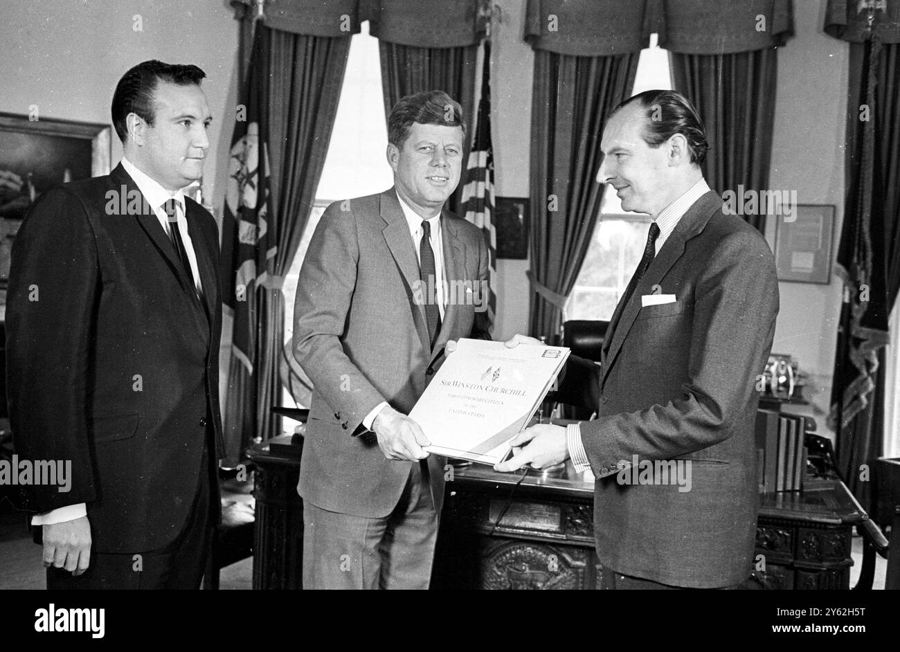 Der britische Botschafter in Washington , Sir David Ormsby Gore , präsentiert Präsident John F. Kennedy im Weißen Haus mit Aufnahmen ausgewählter Reden des britischen Premierministers Winston Churchill . Die Aufnahmen bestehen aus den Höhepunkten von 24 Reden Churchills von der Zeit Münchens bis zum Ende des Zweiten Weltkriegs . Links ist Don Kirshner , Vice President , Music and Recording , Columbia Pictures , Washington DC , USA . 31. Oktober 1963 Stockfoto