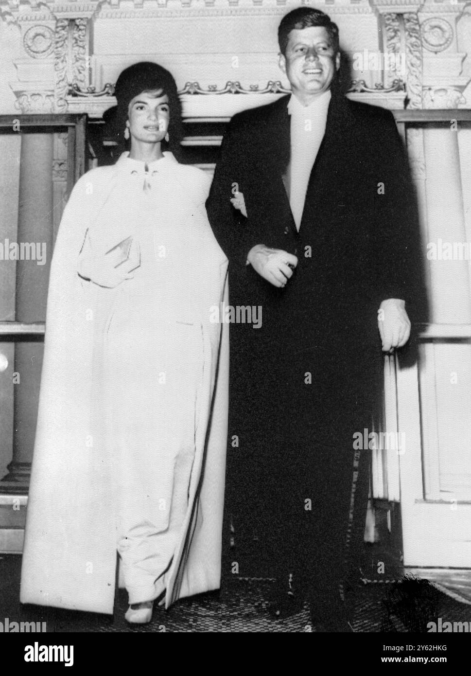 Washington, D.C.: Präsident und Mrs. John Kennedy verlassen das Weiße Haus am 20. Januar, um an dem Ball teilzunehmen. Die First Lady trägt zum ersten Mal ihr Ballkleid in eleganter weißer Ottomane mit hohem Ausschnitt und Ärmeln, die nur den Ellbogen blasen. Die einzige Ornamentik ist eine weiße Stoffrosette, die von Oleg Cassini, dem einunddreißig Jahre alten offiziellen Kleiderdesigner der neuen First Lady in Amerika, entworfen wurde. 21. Januar 1961 9. Mai 1968 Stockfoto