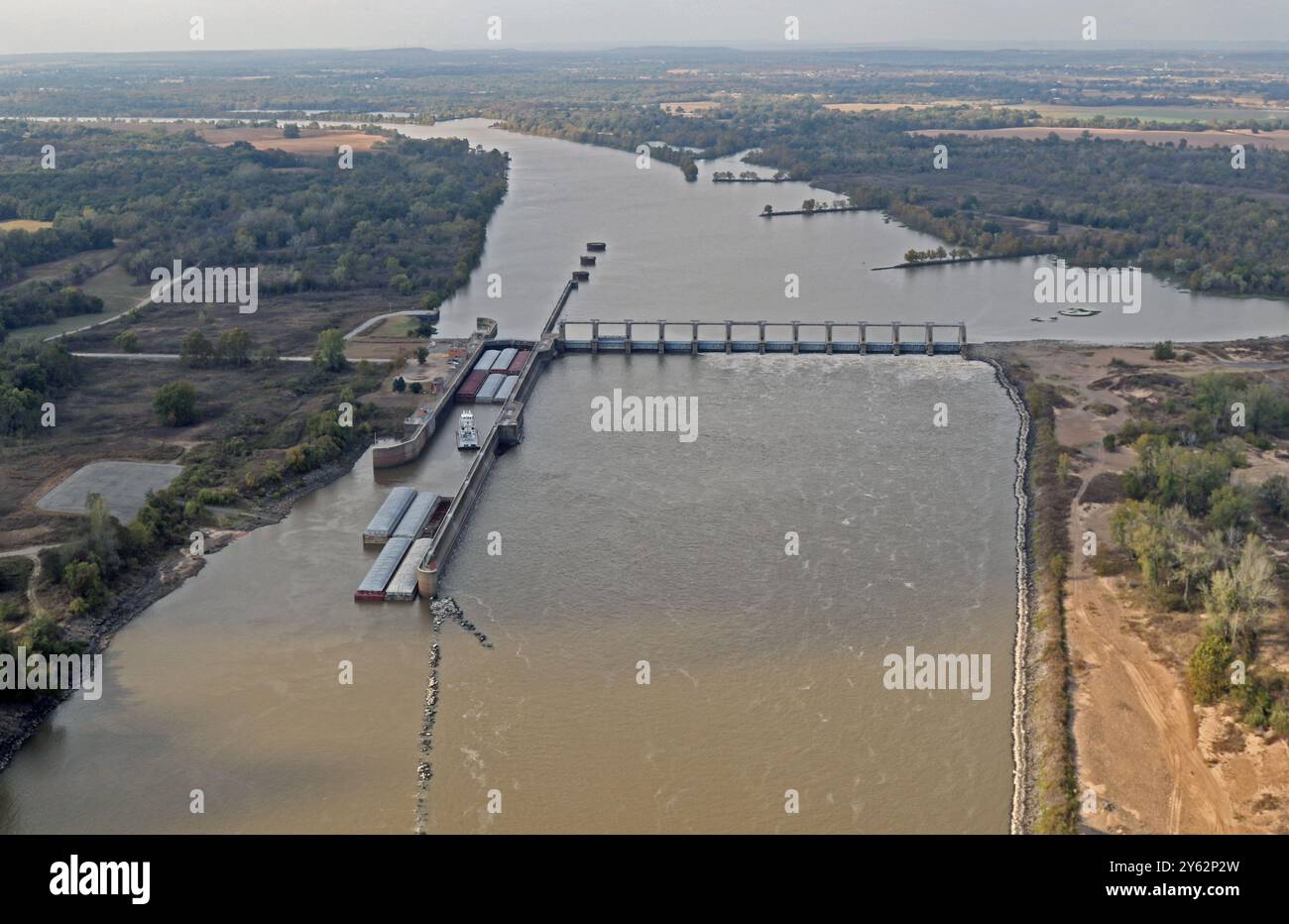 Luftaufnahme eines Schleppers, der Binnenschiffe durch die Schleuse am W D Mayo Lock and Dam 14. November 2016 schiebt. Das Tulsa District, U.S. Army Corps of Engineers, vergab am 20. September einen Bauauftrag an die RKE-Bauunternehmer aus Dexter, Missouri, für die Reparatur der Deiche am Cherokee Chute. Stockfoto