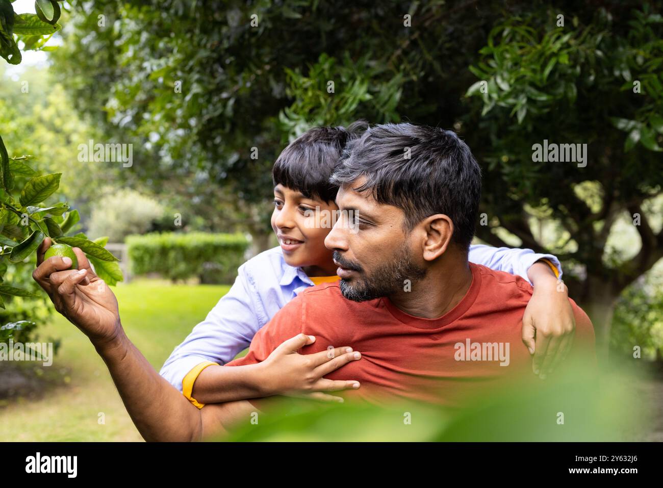 Indischer Vater und Sohn erkunden gemeinsam die Natur im Garten Stockfoto