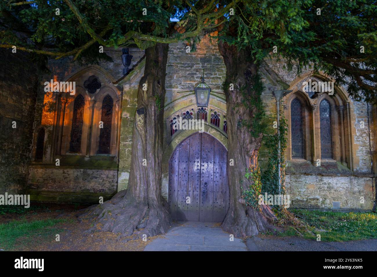 Die historische Kirche St. Edwards Door wurde in einem Harry-Potter-Film verwendet, eingerahmt von zwei großen Eiben in Stow on Wold, Untied Kingdom Stockfoto