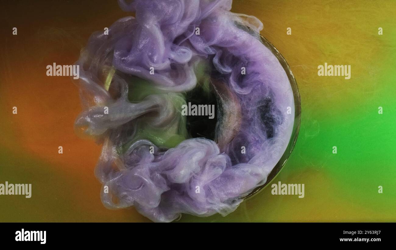 Tintenexplosion. Farbwasser. Lila Glitzer Stream grün orange Nebel Farbe Welle Geheimnis schwarze geometrische Form Zeitreise Kristall abstrakter Hintergrund. Stockfoto