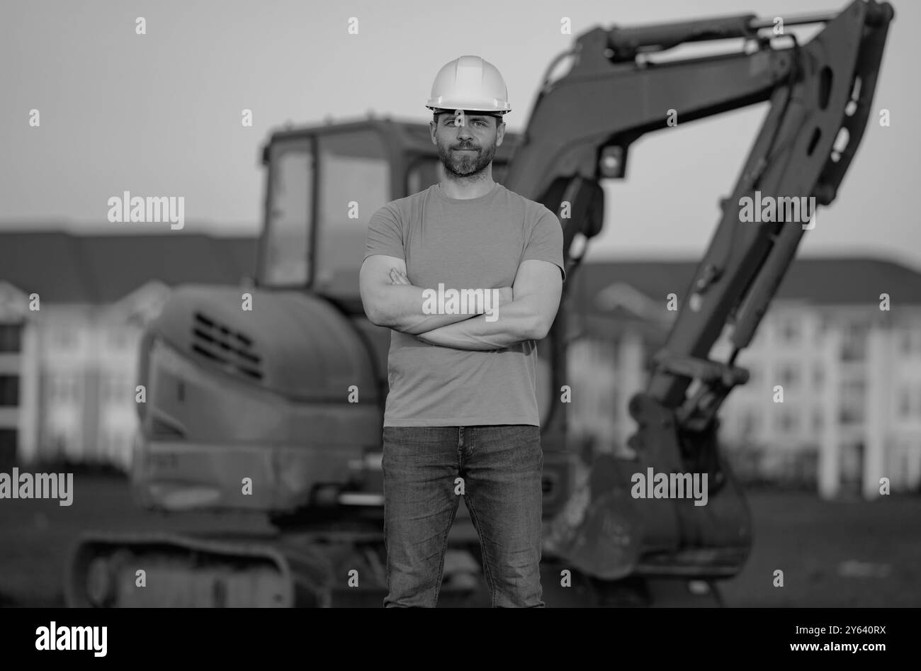 Helmarbeiter auf Baustellen. Bagger Bulldozer männlicher Arbeiter. Bauarbeiter mit Bagger im Hintergrund. Baugewerbe Stockfoto