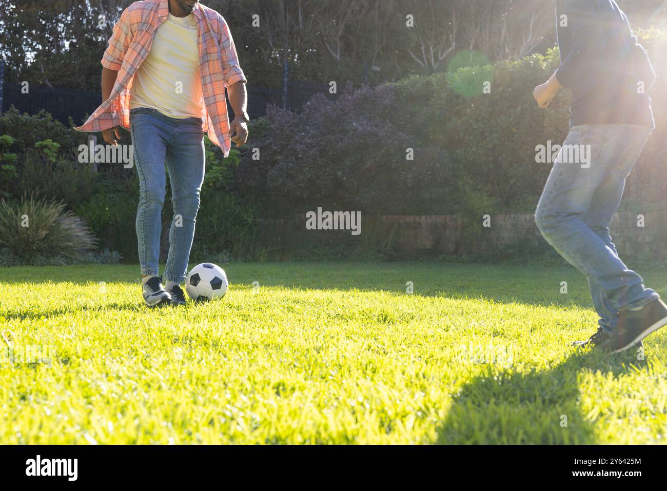 Fußball auf Gras spielen, indischer Vater und Sohn genießen gemeinsam Outdoor-Aktivitäten, Kopierraum Stockfoto