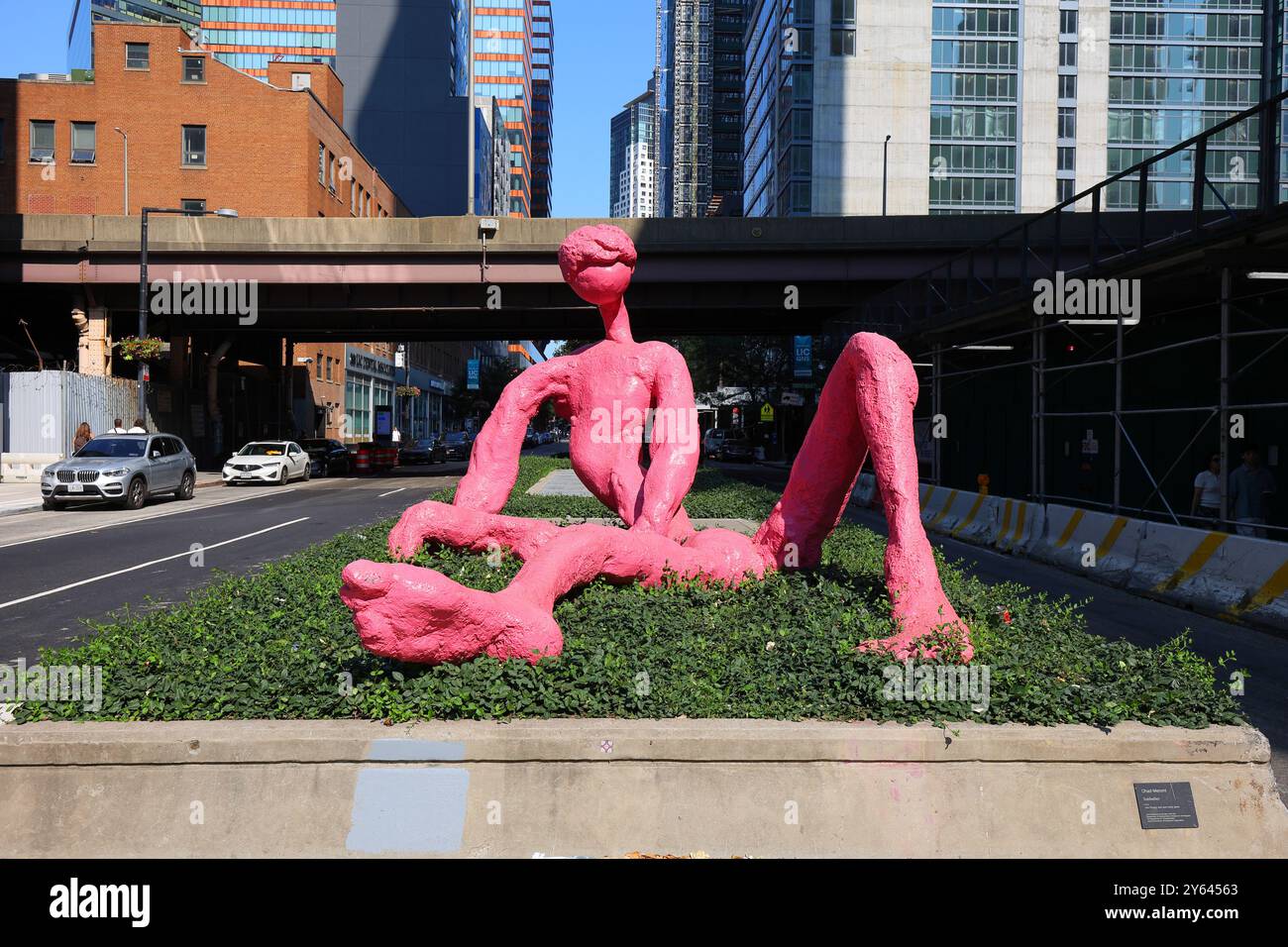 Eine Bronzegusskulptur Sunbather von Ohad Meromi in Pink an einer Kreuzung von Long Island City in der Nähe des Court Square. Statue Stockfoto