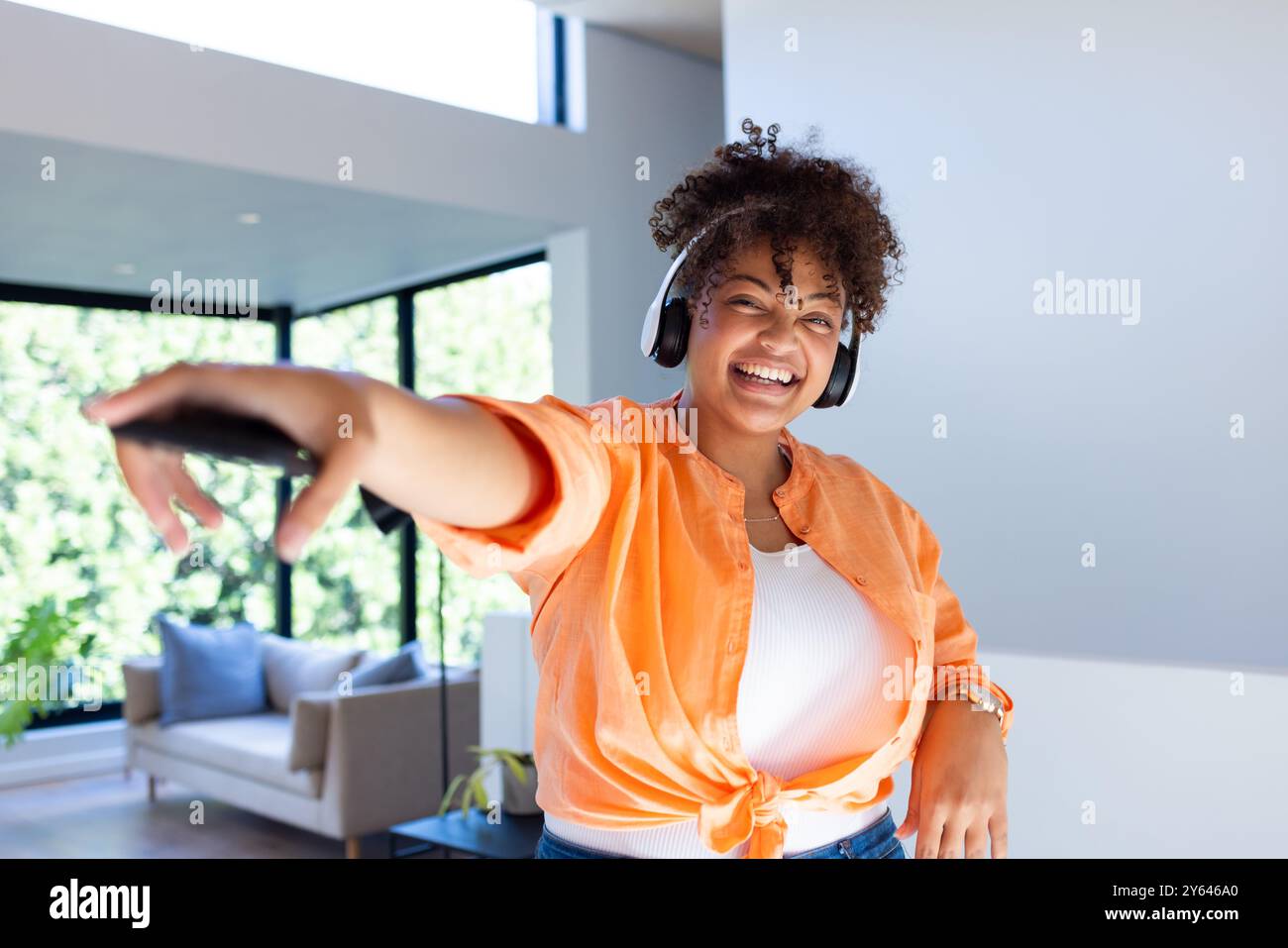 Tanzen und lächeln, Frau im Kopfhörer, die zu Hause Musik genießt Stockfoto