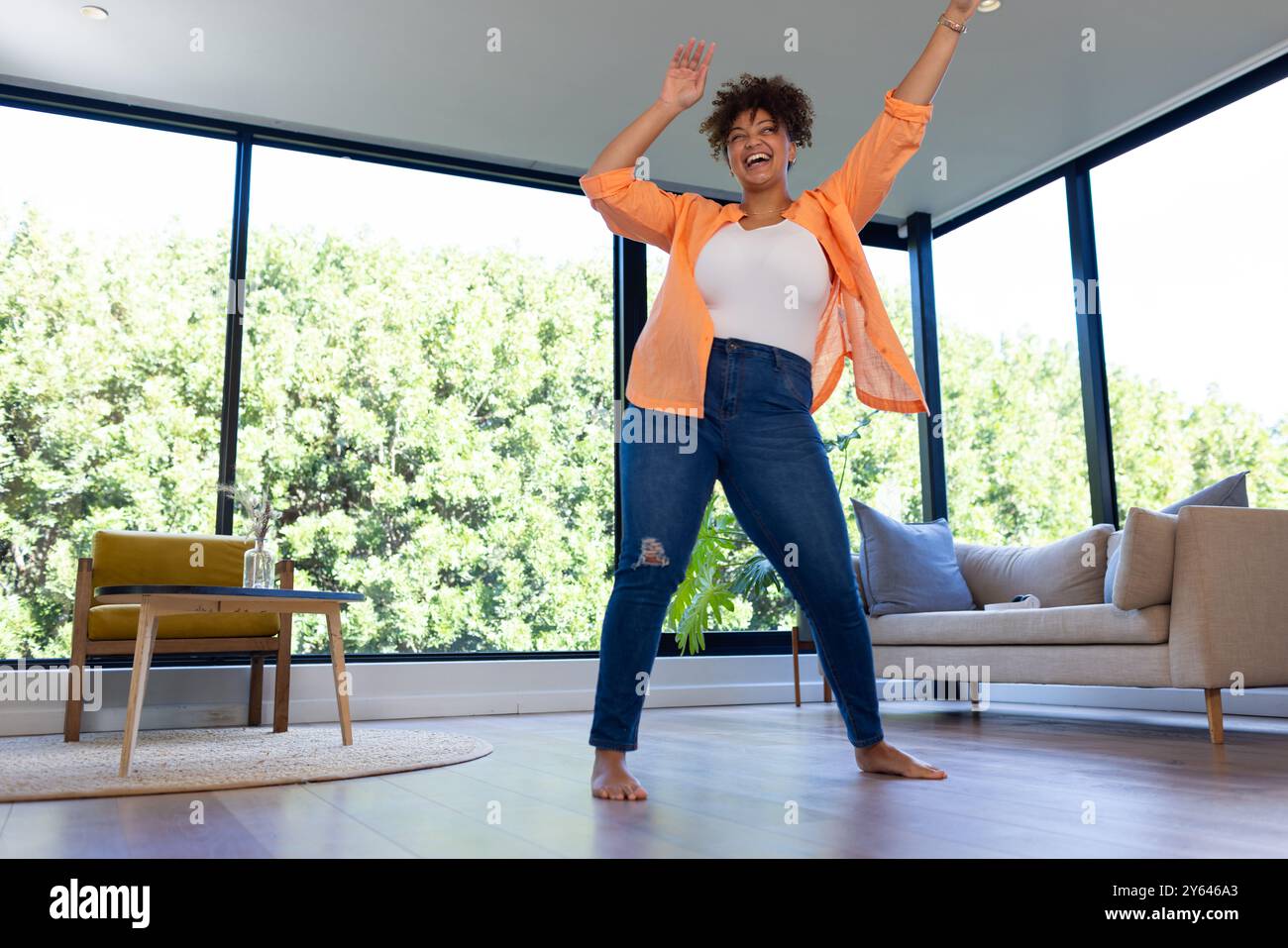 Tanzt energisch, plus große Frau, die zu Hause Routine genießt Stockfoto