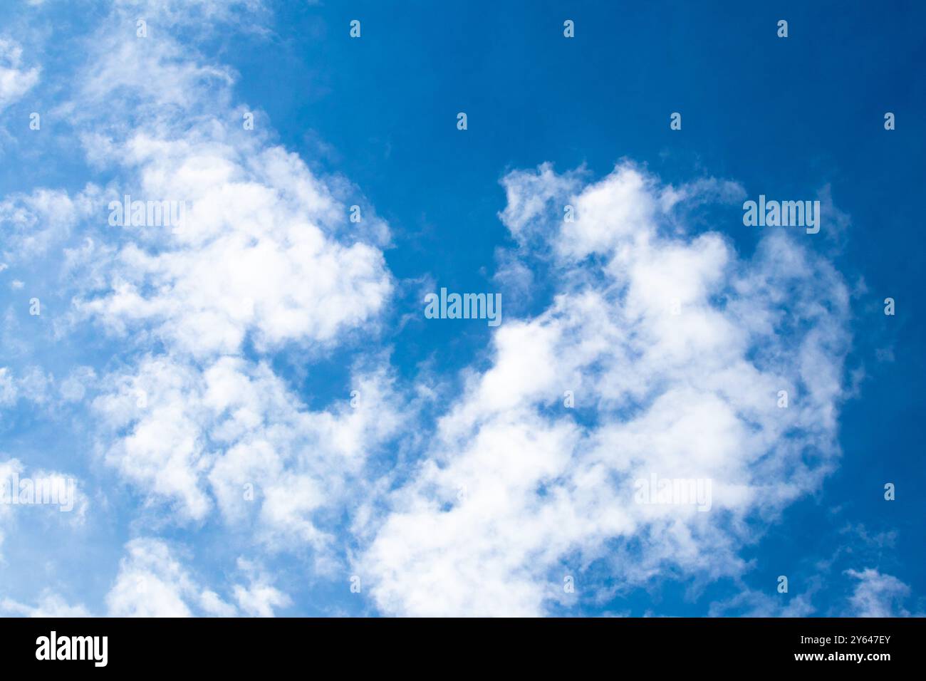 Textur, Konzept der Musteridee. Bewölkter blauer Himmel, weißer Wolkenhintergrund mit tiefblauem Himmel. Tapete mit Sonnenlicht. Horizontales Foto. Keine Personen. Stockfoto