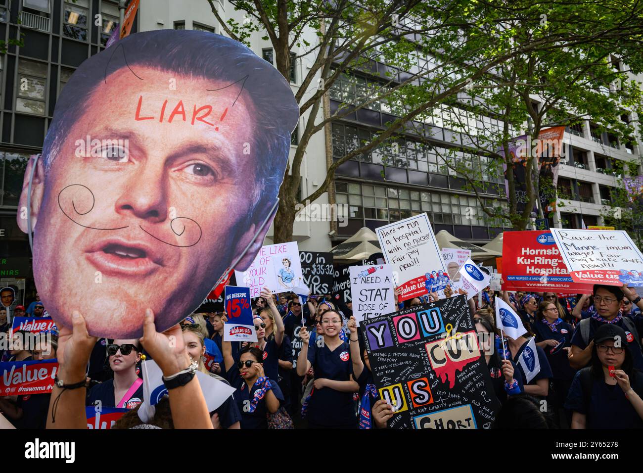 Sydney, Australien. September 2024. Demonstranten sahen, wie sie Plakate und Fotos des Premierministers von New South Wales, Chris Minns, hielten, während sie in Richtung des Parlaments von NSW marschierten. Krankenschwestern und Hebammen in ganz New South Wales streikten 24 Stunden und marschierten vom Hyde Park durch Sydneys Straßen zum Parlament in New South Wales und forderten eine bessere Gehaltserhöhung. Der Verband fordert eine Lohnerhöhung von 15 %, während die Regierung nur 3 % angeboten hat. (Foto: George Chan/SOPA Images/SIPA USA) Credit: SIPA USA/Alamy Live News Stockfoto