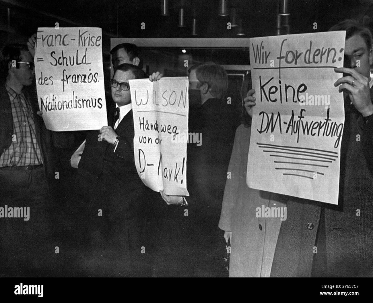 Studenten demonstrierten gestern im Saal des Wirtschaftsministeriums hier , als die Dringlichkeitssitzung der Zehnergruppe im Wirtschaftsministerium Bonn stattfand . Die etwa 20 Studenten protestierten gegen den Druck auf die Bundesrepublik Deutschland , die Mark aufzuwerten . Auf dem Plakat im Zentrum steht " Wilson : Hands off the D Mark " die Finanzminister und Zentralbanker der Gruppe der 10 - der führenden nichtkommunistischen Industrieländer der Welt - haben heute eine achtstündige Notsitzung beendet , ohne eine Einigung zu erzielen , Bonn , Bundesrepublik Deutschland . 21. November 1968 Stockfoto