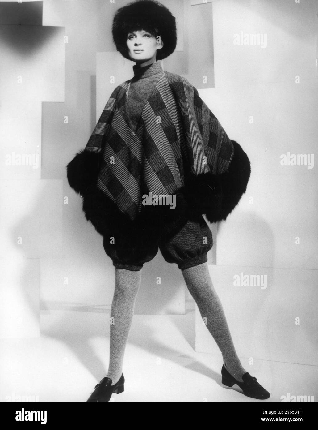 Ein Outfit von Naka aus elastischem Wollgewebe mit knielanger Hose und kariertem Mantel in zwei Grautönen. Schwarze Fuchsborten und Hut. Graue Wollstrümpfe. Kinderschuhe. 19. April 1968 Stockfoto