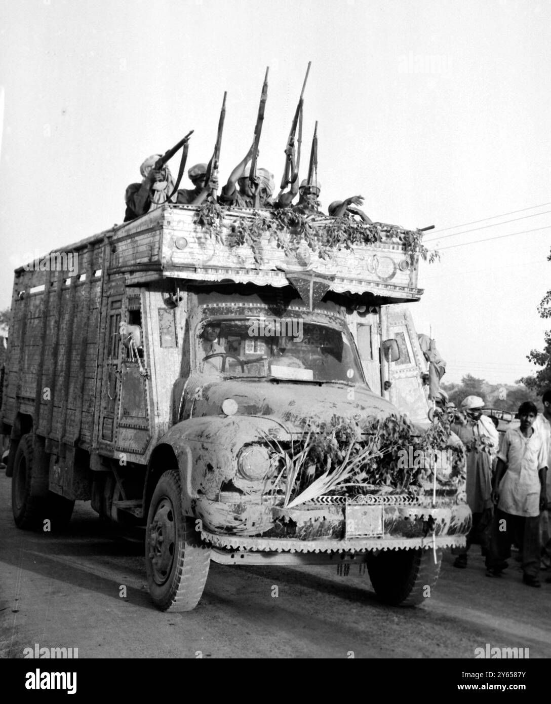 Bewaffnete pakistanische Pathan-Hill-Stammesleute , die in einem stark getarnten Fahrzeug auf dem Weg zur Kampffront im Gebiet von Sialkot in Pakistan transportiert wurden , 14 . September . Während gestern im Indo-Pakistan-Krieg Friedensbewegungen unternommen wurden , soll die indische und pakistanische Infanterie in einer der heftigsten Schlachten des Kampfes in der Nähe der Stadt Sialkot zusammengetreten sein . 17. September 1965 Stockfoto