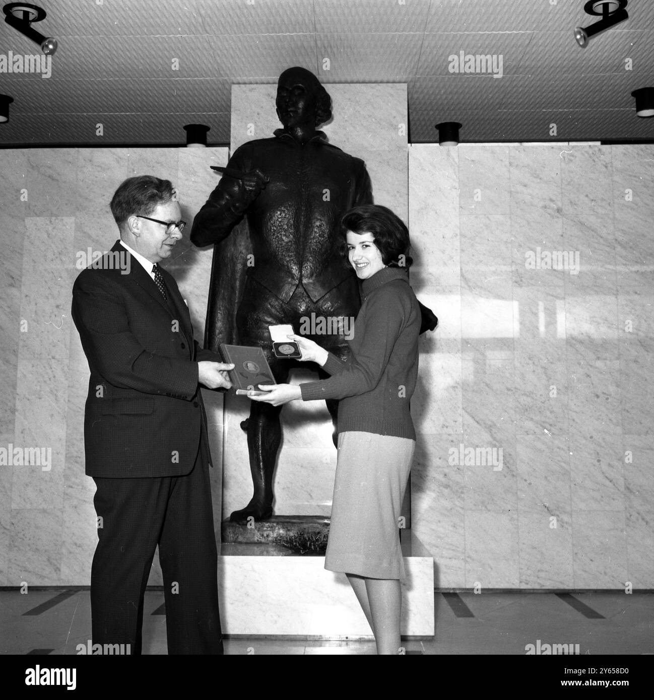 Herr Levi Fox , MA, FSA , Direktor und stellvertretender Vorsitzender des Shakespeare Anniversary Council 1964 in Stratford-on-Avon , überreicht Miss Mary Harrisson aus Paarl, Kapprovinz, Südafrika, eine Kopie von Shakespeares Stücken und ein Medaillon des Bard, als sie das neue Shakespeare Centre besuchte. Mary, die Gewinnerin des Shakespeare-Wettbewerbs in Schulen in ganz Südafrika, gewann eine zweiwöchige Reise nach Großbritannien während der Shakespeare-Feierlichkeiten , die am 23. April, dem 400. Geburtstag von William Shakespeare, stattfinden . 21. April 1964 Stockfoto