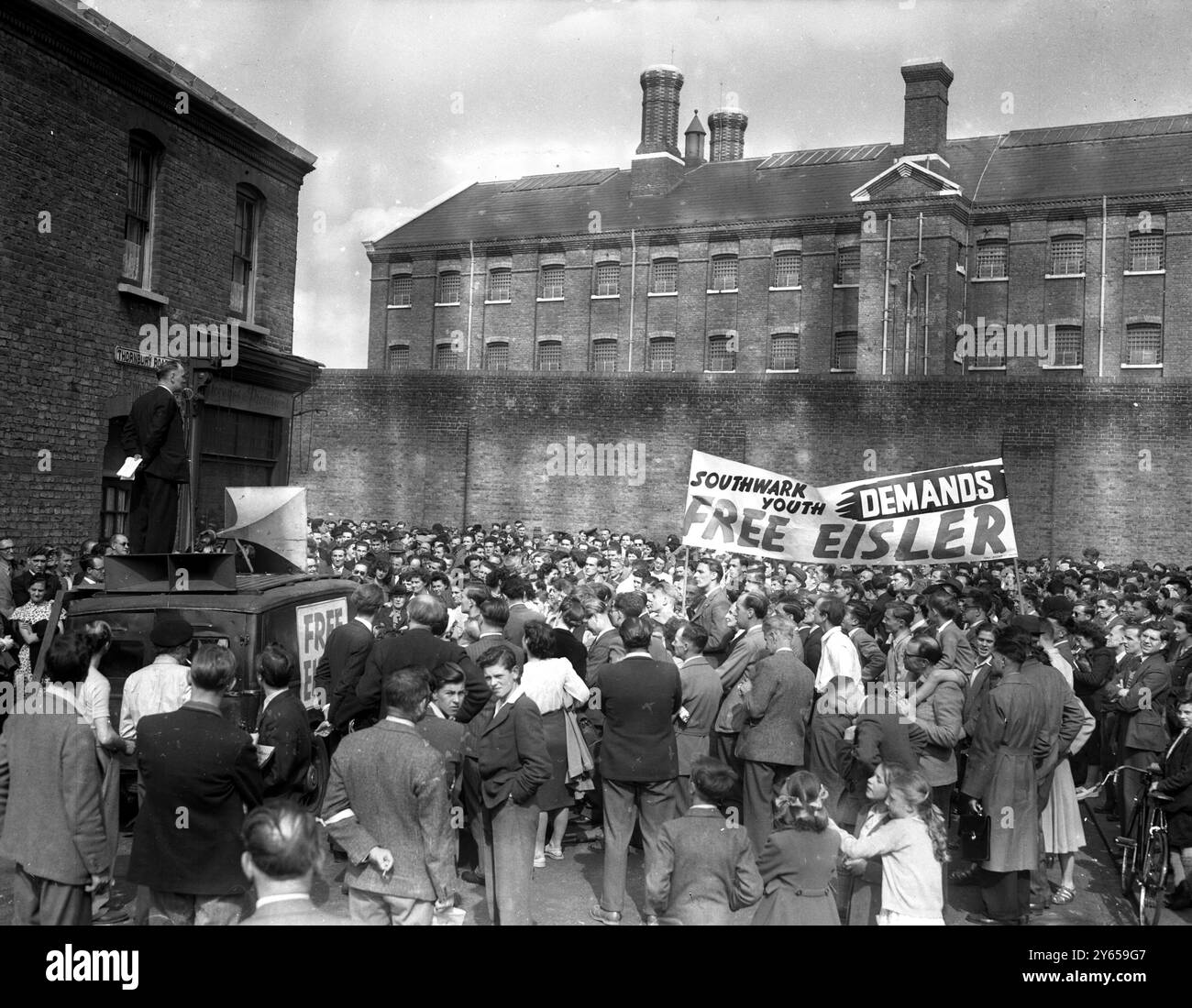 Die Kommunisten veranstalteten heute ein Treffen vor dem Brixton Prison , London , wo Eisler derzeit inhaftiert ist . Gerhard Eisler , in Deutschland geborener Kommunist aus den Vereinigten Staaten von Amerika , wurde am 14 . Mai 1949 auf dem polnischen Linienschiff MS Batory verhaftet , nachdem das Schiff in Cowes Roads auf dem Weg von Gdymia angekommen war . Der im Rahmen des Auslieferungsgesetzes von 1870 erteilte Haftbefehl wurde auf Ersuchen des US-Justizministeriums ausgestellt . Hier die allgemeine Ansicht der Demonstration in Prcess, die das Brixton-Gefängnis im Hintergrund zeigt . Die Sitzung wird von Herrn Papworth angesprochen . 22. Mai 1949 Stockfoto