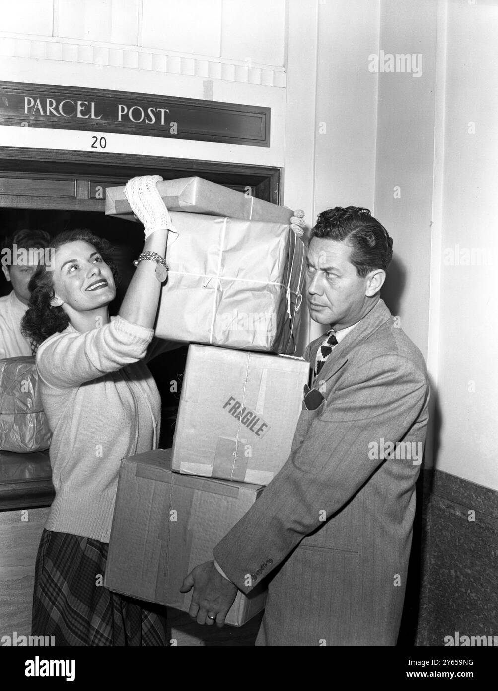 Beryl Davis , ein englischer Song-Star der NBC's Hit Parade , hilft Ehemann Peter Potter, ein paar Weihnachtspakete für die Leute zu Hause zu schicken . USA 1949 Stockfoto