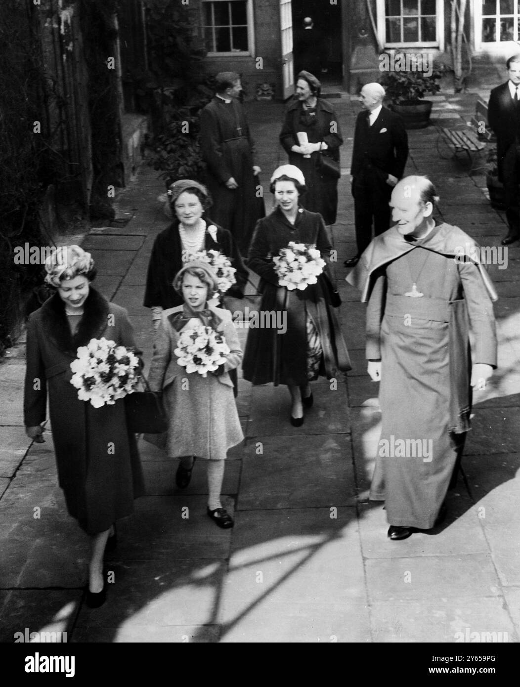 Zum ersten Mal fand der Royal Maundy Service in Windsor, Berks, in der St. George's Chapel statt . Jeder trägt einen Blumenstrauß , Mitglieder der königlichen Familie , von vorne nach hinten , Königin Elizabeth , Prinzessin Anne , Königin Mutter und Prinzessin Margaret , gehen mit dem Pfarrer Bischof Eric Hamilton , dem Dekan , nach dem Royal Maundy Service . Die Königin verteilte das Maundy-Geld. 26. März 1959 Stockfoto