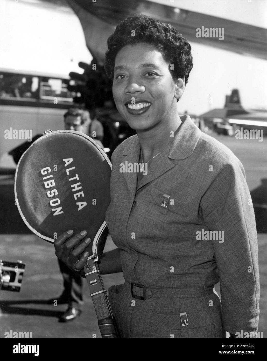 ALTHEA Gibson , die amtierende Wimbledon-Frauenmeisterin , kommt hier mit Tennisschlägern in der Hand am Flughafen London an . Obwohl Althea nicht am Wettbewerb teilnimmt , wird er für eine Abendzeitung über die Wimbledon Championship berichten . Juni 1959 Stockfoto